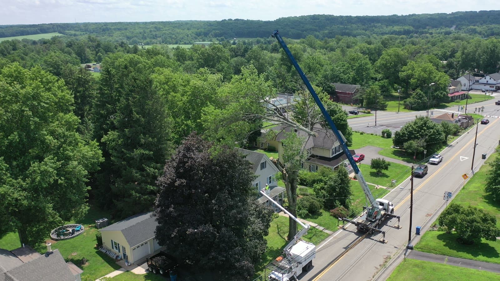 Aerial view of crane and bucket truck on a residential street